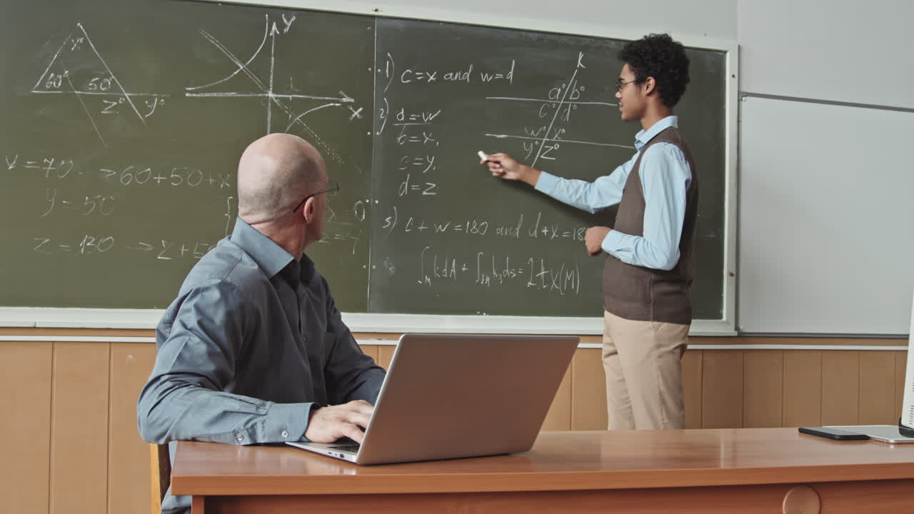 Mixed Race Student Solving Geometry Problem at Blackboard