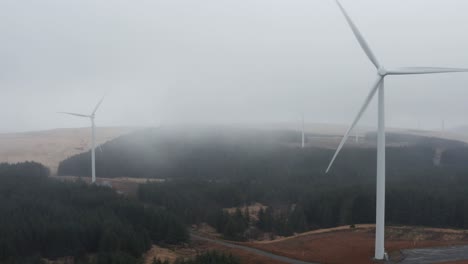toma aérea estática sombría de turbinas de parques eólicos en nubes pesadas y lluvia en la montaña de rhigos de los valles galeses