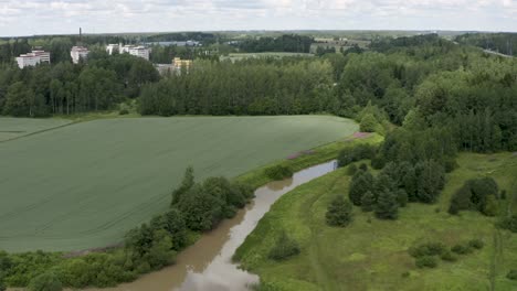 Beautiful-aerial-pan-of-the-Kerava-countryside-with-pink-flowers-on-the-bank-of-the-Keravanjoki-River-in-Kerava,-Finland