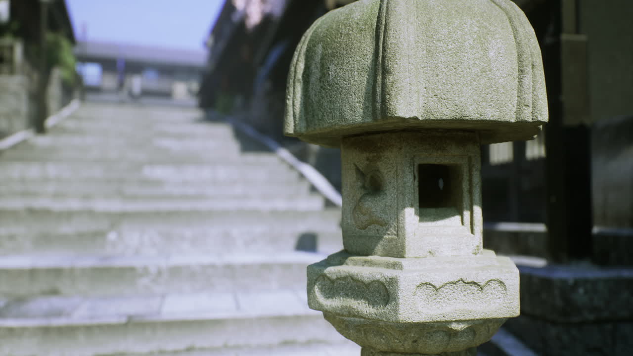 Stone lantern by the stairs of an ancient temple during the day