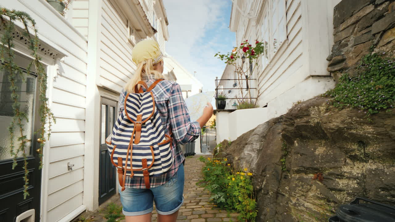 turista con un mapa en sus manos caminando por las estrechas calles de bergen en noruega vacaciones en s