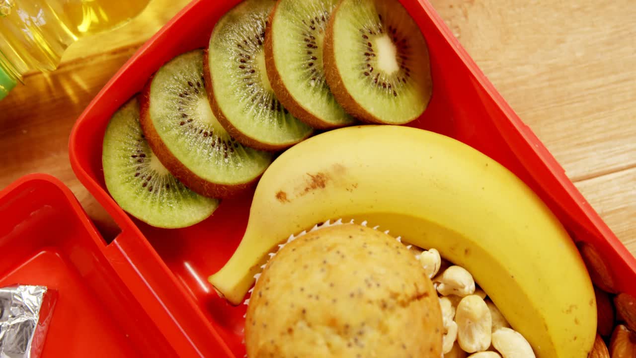 primer plano de frutas secas con plátano, kiwi y muffin