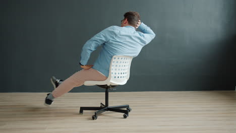 man sitting in an office chair in funny poses