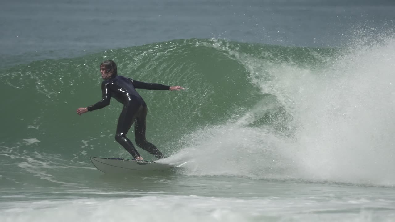 A surfer initiates a powerful bottom turn inside a barreling wave, preparing for a tube ride with speed, control and style