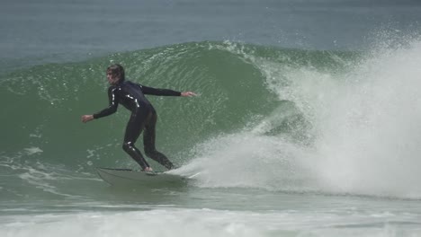 a surfer initiates a powerful bottom turn inside a barreling wave, preparing for a tube ride with speed, control and style