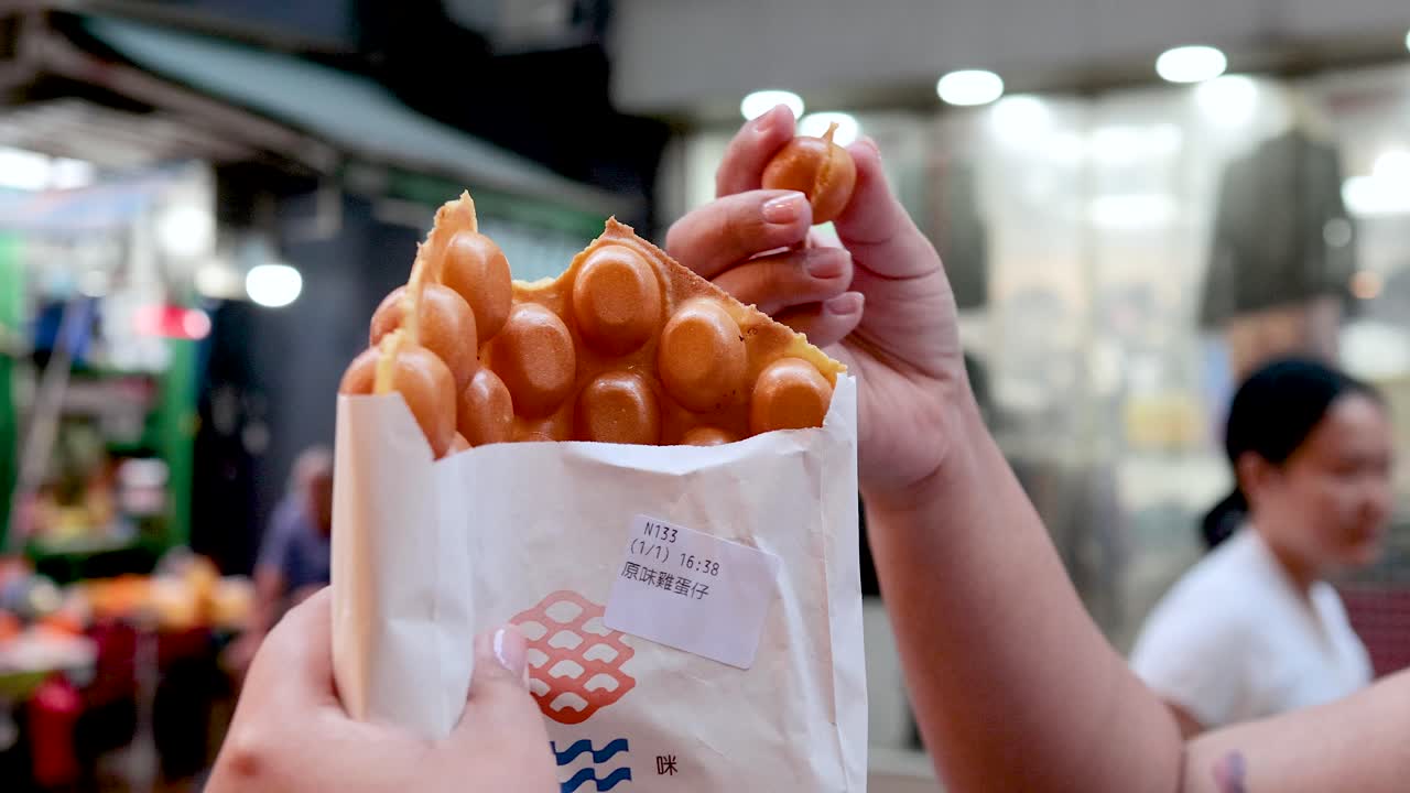 persona saboreando comida callejera en un mercado bullicioso