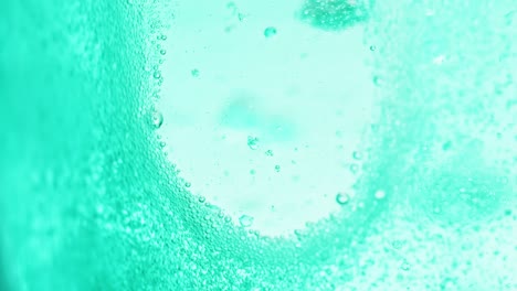 toma macro de agua azul brillante con muchas burbujas brillantes que dejan un pequeño lugar sin burbujas