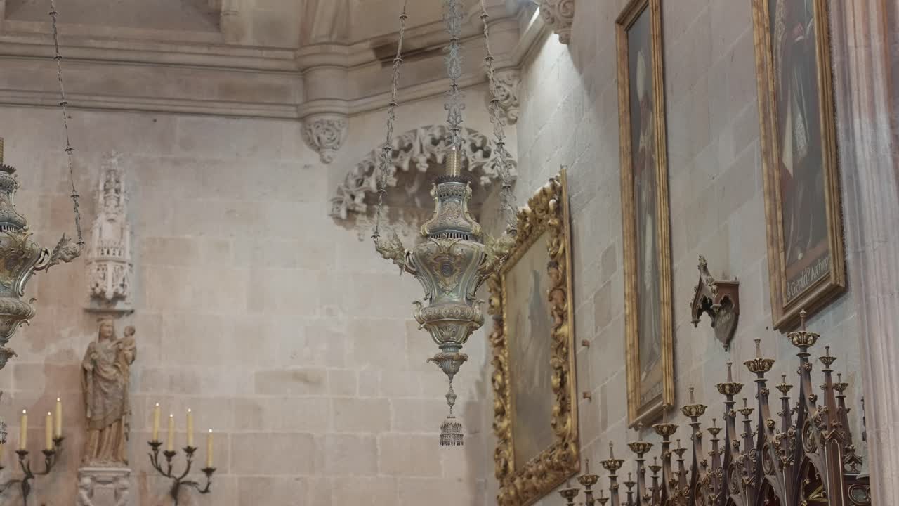 incensario de metal intrincado suspendido bajo una luz suave en el interior de una iglesia.