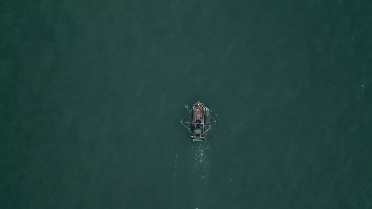 A fishing boat trawls the ocean for fish.