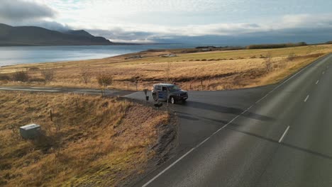 tomada de un avión no tripulado de un coche en las llanuras y la carretera en islandia durante el invierno