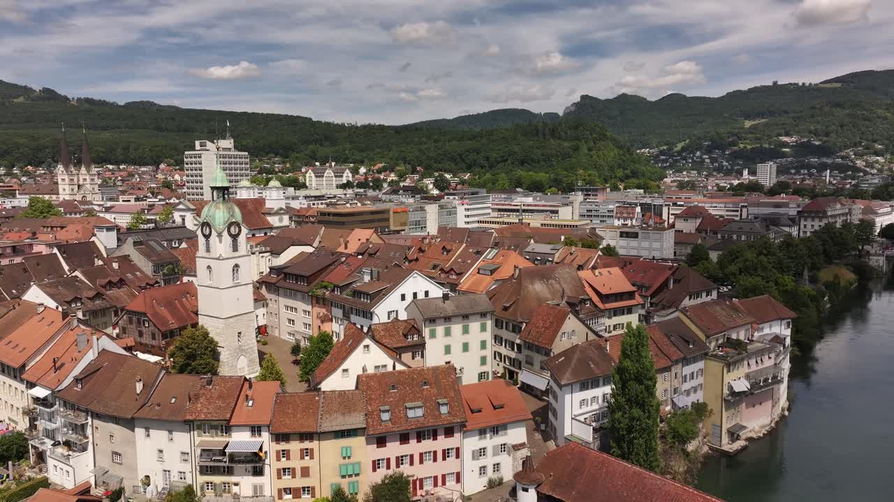 aerial - old wooden bridge crosses river aare beside clock tower in olten solothurn switzerland