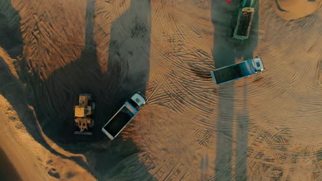 aerial view of construction site with excavator and dump trucks