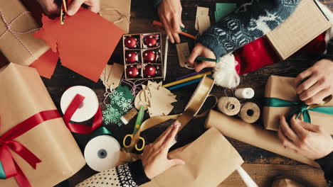 hands wrapping christmas presents arial view