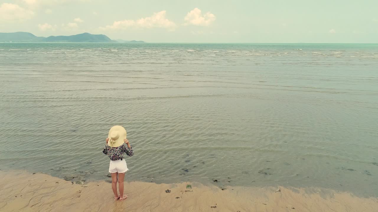 4K woman walk on the beach, foot print on sand texture and coconut tree on the beach photo by drone.