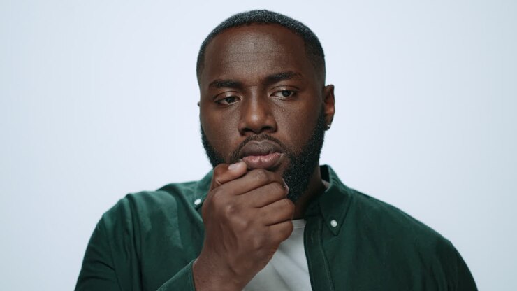 Portrait african man checking breath freshness in studio. Guy preparing for date