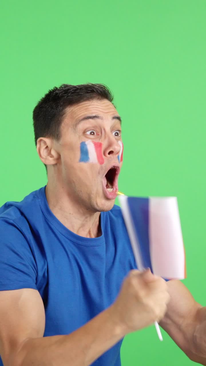 French supporter screaming and waving a national flag looking away