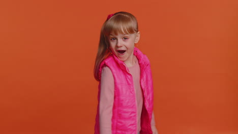funny joyful girl making playful silly facial expressions, grimacing, fooling around showing tongue