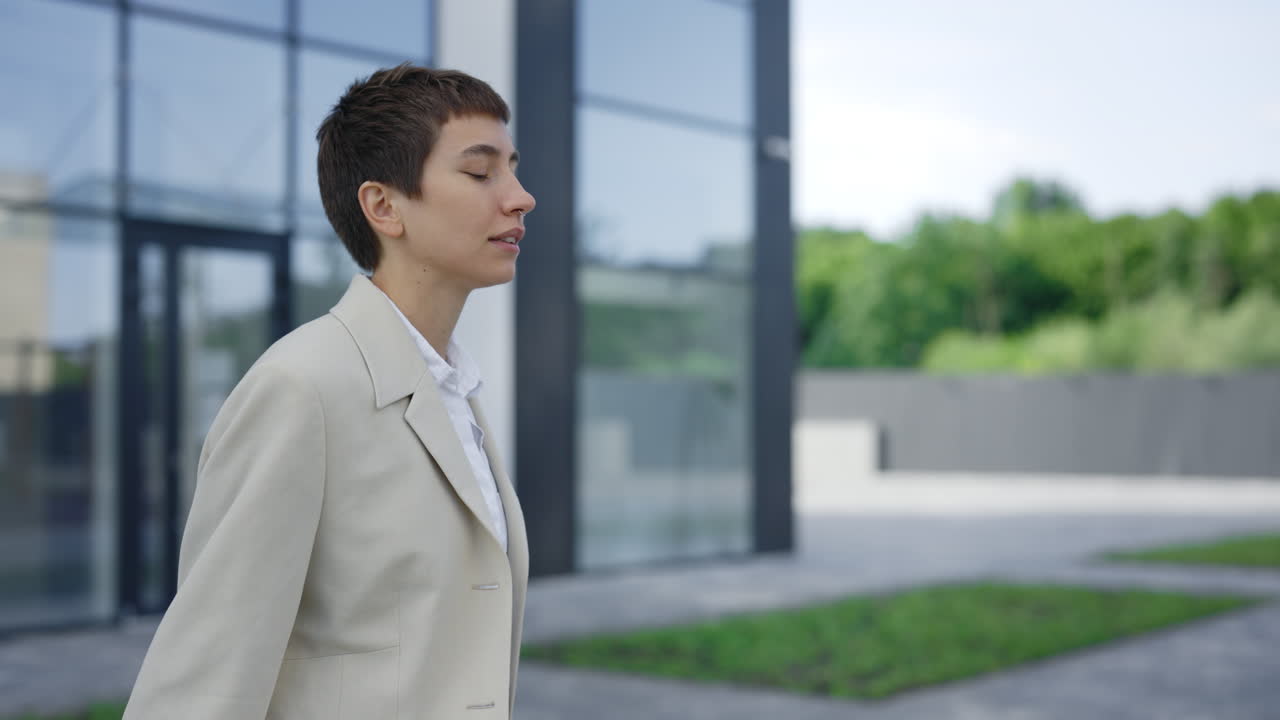 Woman talking on phone outdoors near a building
