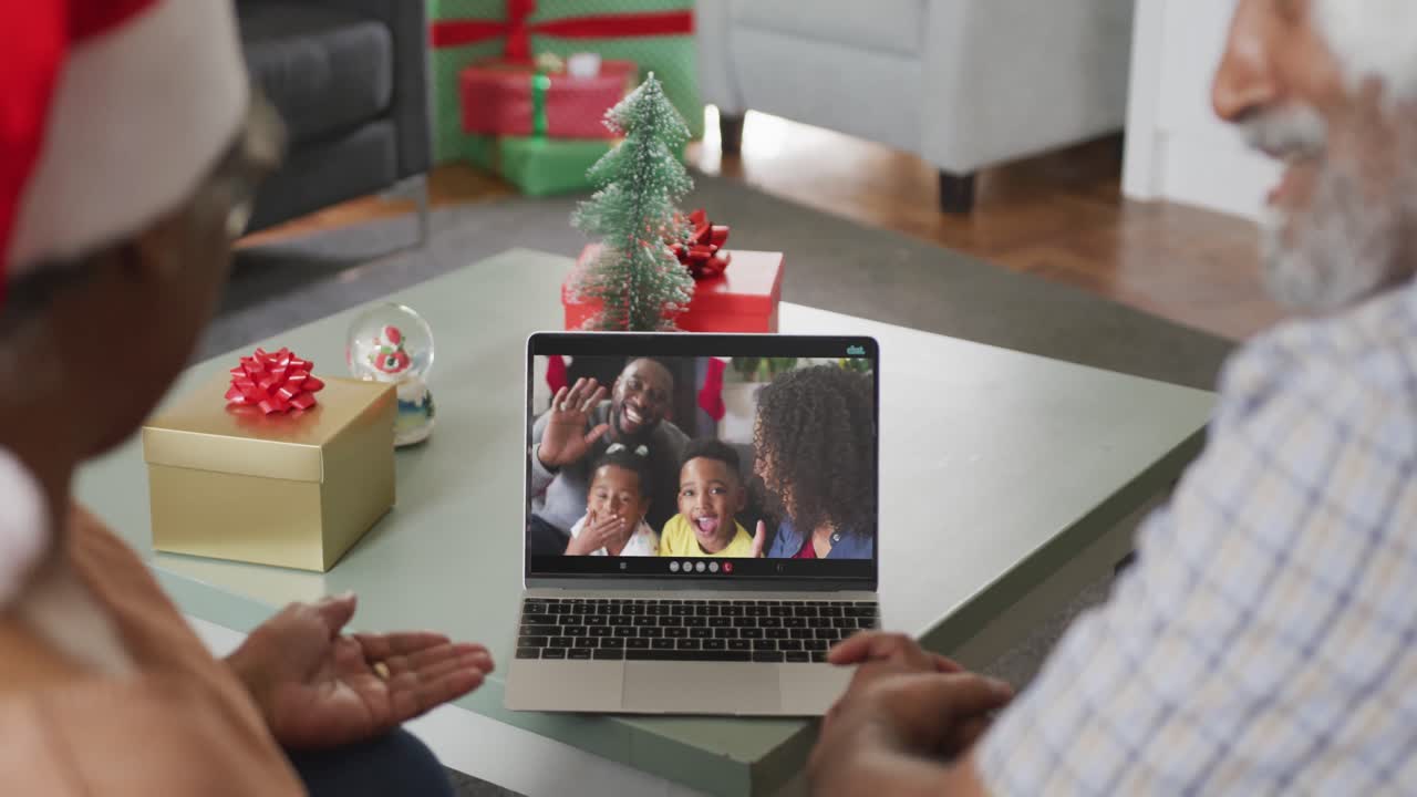 feliz pareja afroamericana en videollamada en computadora portátil con la familia en tiempo de navidad