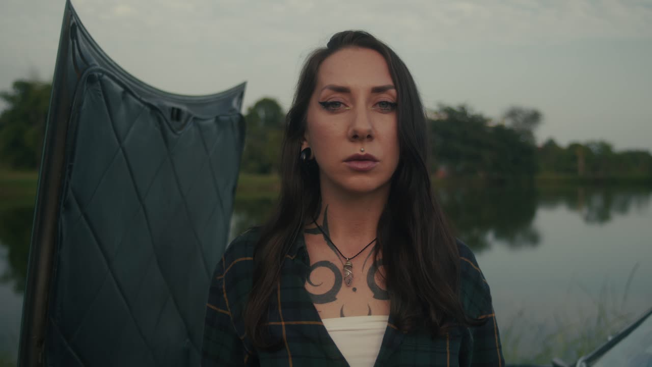 Woman near a vintage car by a lake