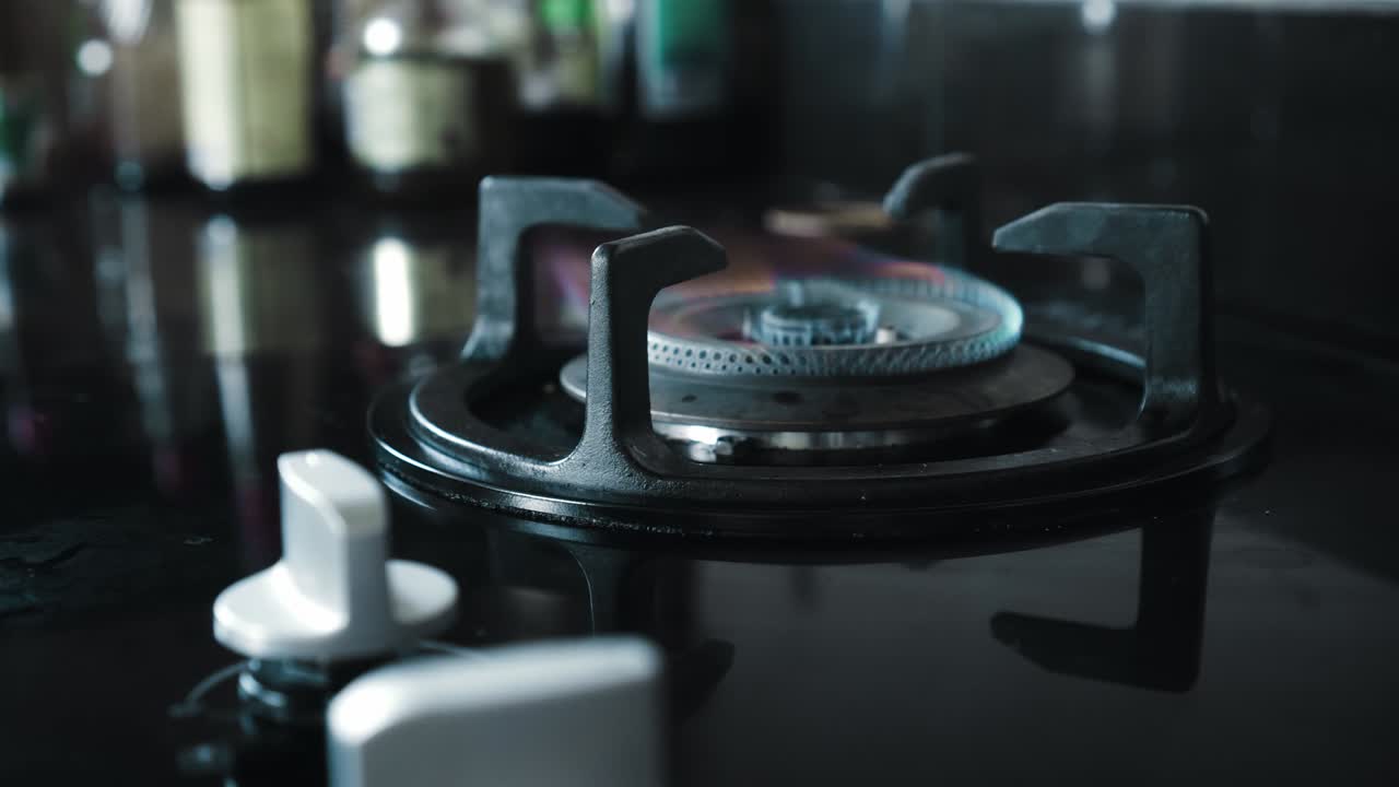 부에서 파란색과 빨간색으로 불타는 불꽃이 있는 검은색 가스 스토브의 비디오