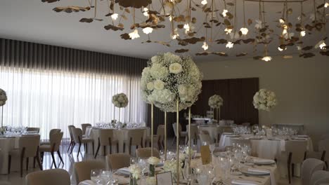 elegant reception hall with white floral centerpieces and golden ceiling decor