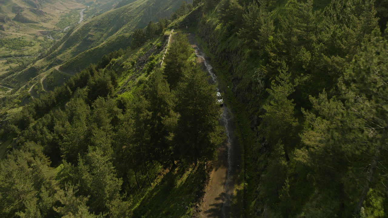 tire hacia atrás sobre el coche que viaja en el camino de tierra de la ladera de la montaña cerca de vardzia, georgia