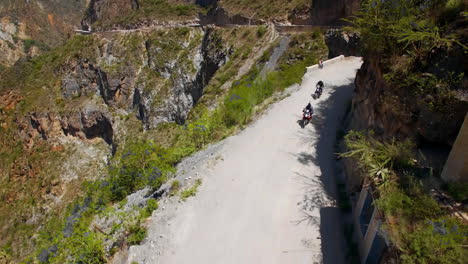 aerial of motorcycle riders riding motorbike on mountain roads