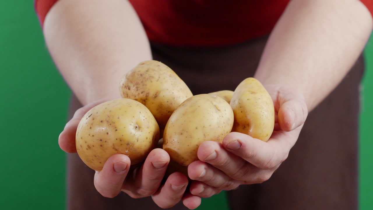 el hombre con una patata fresca sin pelar.