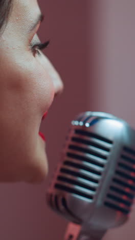 una cantante femenina es capturada cantando alegremente desde el ángulo correcto con un micrófono vintage en foco y un fondo borroso