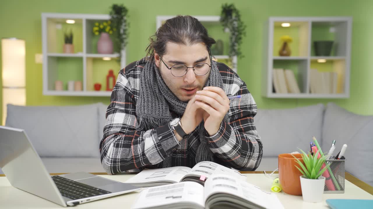 el joven frío en casa está estudiando.