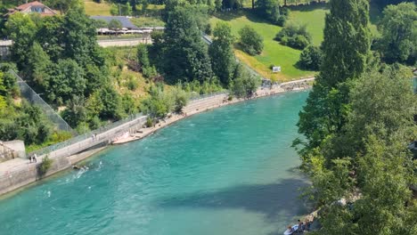 view of the turquoise aare river and the bärengraben bear enclosure in central bern, switzerland, on a sunny summer day
