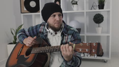 Male-Urban-Musician-Singing-And-Playing-Guitar-At-Home-1