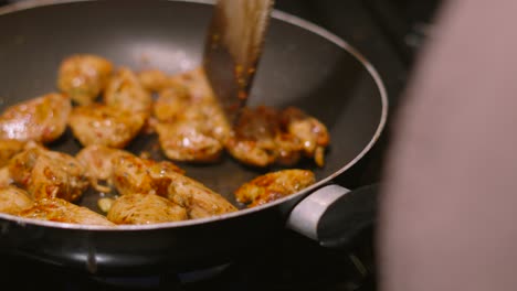 hot frying pan with delicious chicken chunks cooking in marinated chinese style sauce. oriental cuisine dish being cooked 4k.