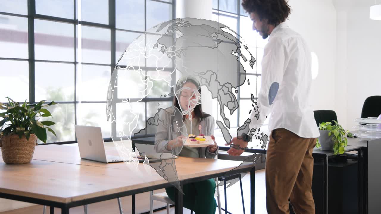Coworker offering dessert with candle to colleague at office rotating globe overlaying for birthday