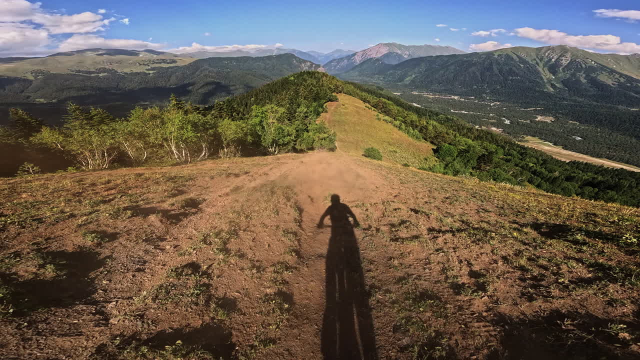 Ponto de Vista: Sombra de Ciclista em Mountain Bike Descendo uma Trilha Cênica