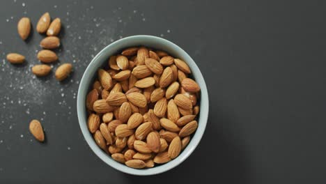 Video-of-fresh-fruit-almonds-in-a-bowl-on-grey-background