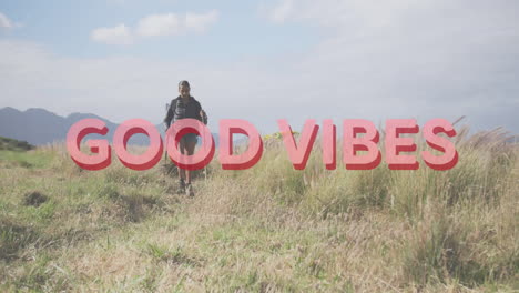 animation of the words good vibes in pink over woman hiking in countryside