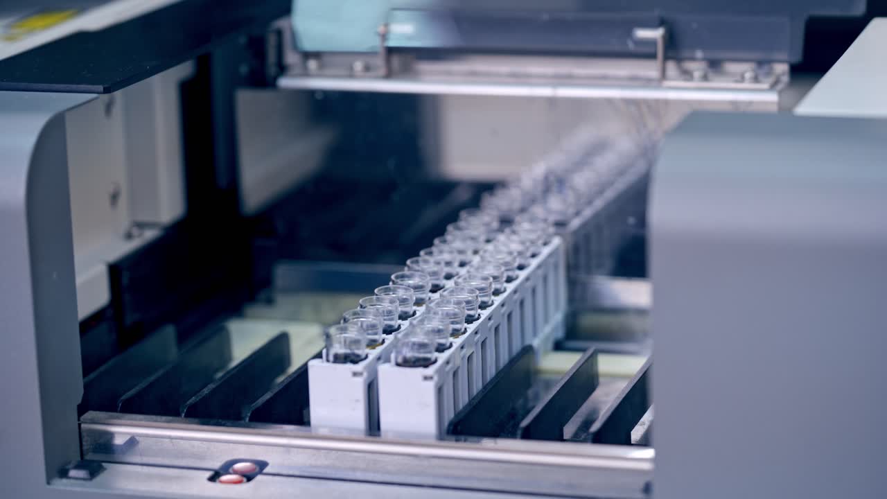 Contemporary equipment in the laboratory. Hands of laboratory worker putting vials into the modern machine in clinic. Modern device for testing blood samples.