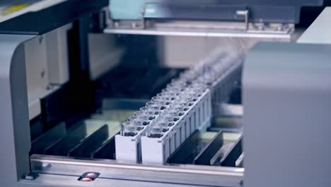 contemporary equipment in the laboratory. hands of laboratory worker putting vials into the modern machine in clinic. modern device for testing blood samples.