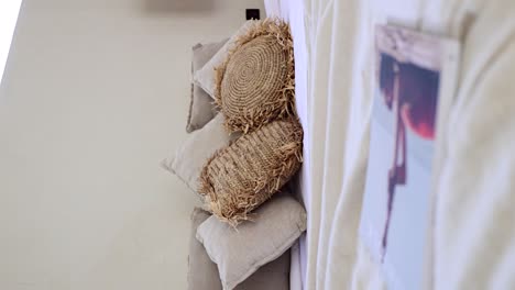 vertical boho style bedroom - bohemian rustic throw pillows handmade of straw paper on a white bed cover - dolly backwards