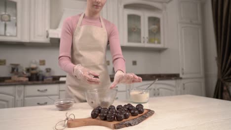 top bottom shot of the young attractive woman making chocolate candy balls. homemade sweets making concept. tasty and healthy food