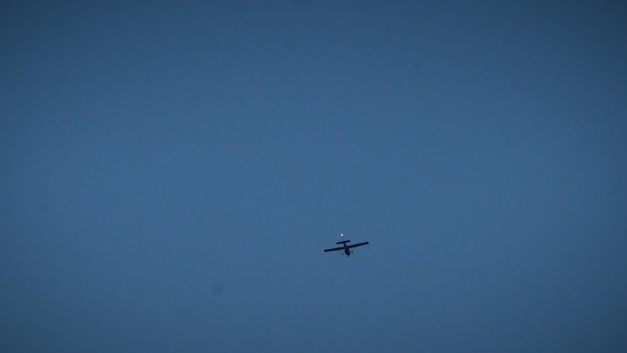 밤에 도시 상공을 비행하는 작은 비행기 가까이