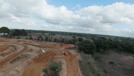 Aerial-view-of-motocross-rider-on-dirt-track-surrounded-by-trees