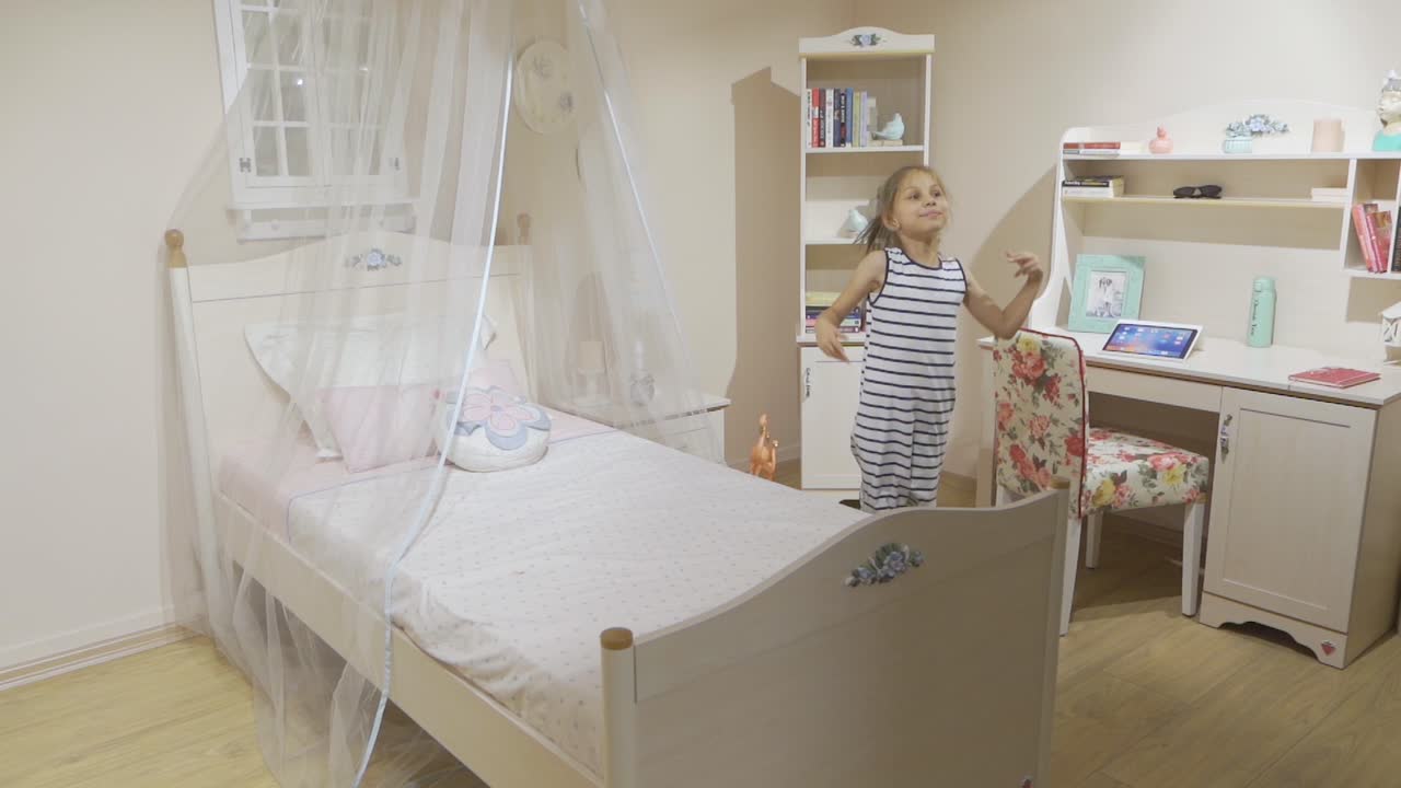 La bambina salta da sola nella sua stanza.