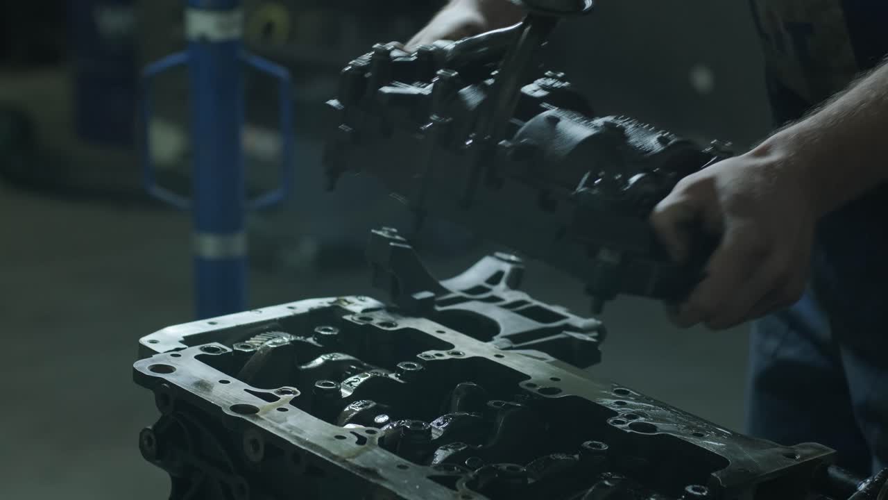 mecánico de automóviles en el garaje con el motor del automóvil después de quitar la parte de la cubierta. las manos del mecánico abren el motor para la reparación. servicio automovilístico