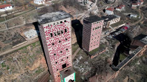 Altas-Torres-De-Fábrica-De-Tratamiento-De-Minerales-Abandonada-Con-Paredes-Pintadas-En-Perrenjas,-Albania