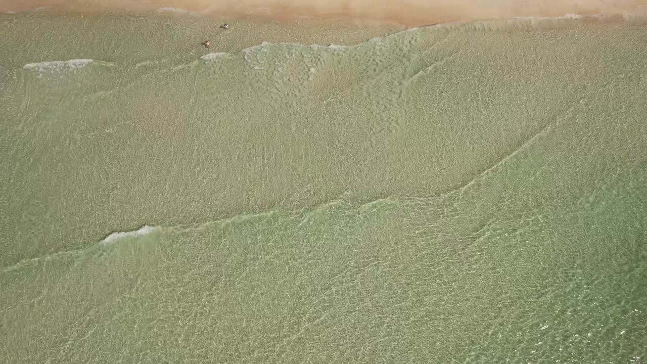 Crystal-clear Waves Crashing Against the Sand - Bird's Eye View