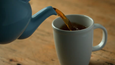 el té caliente se vierte en la taza azul.