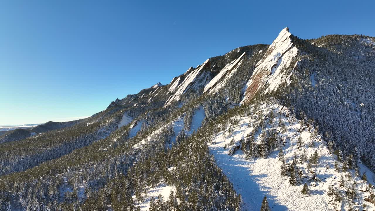 콜로라도의 볼더에 있는 콜로라도 플래티론과 차우타쿠아 공원의 천천히 상승하는 공중 드론, 눈이 내리는 밝은 겨울 아침.